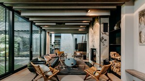 Una sala de estar moderna con un sofá, sillas, una mesa de centro y una chimenea.