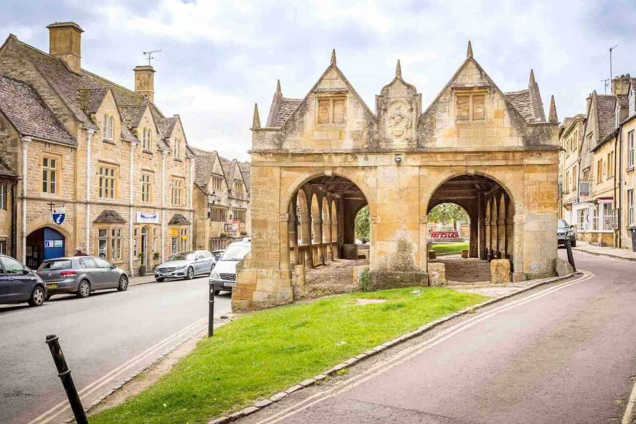 Un arc en pierre d’époque, de style traditionnel, flanqué de bâtiments à l’architecture classique.