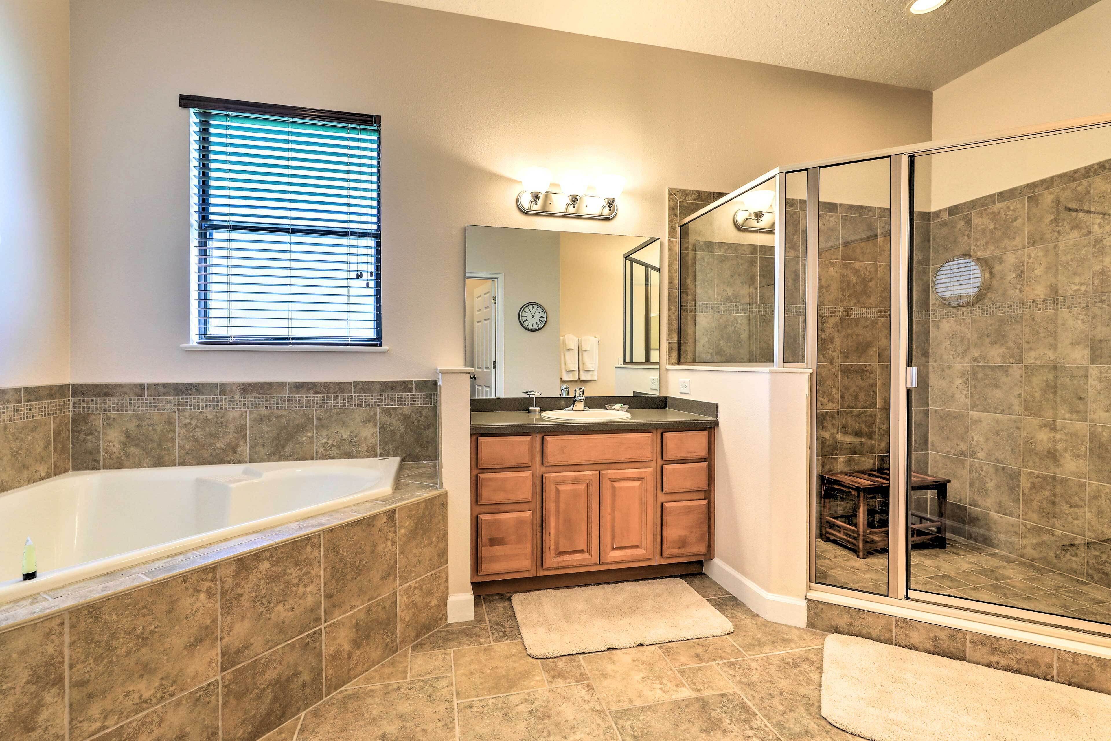 A modern bathroom with a freestanding bathtub, a glass-enclosed shower, and a vanity with a mirror.