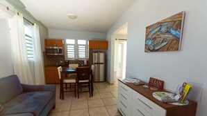 A compact living space with a kitchenette, a dining area, and a sofa. - Sea Turtle Studio – Upscale Waterview Retreat, Stunning Sunrises & Full Kitchen! (Culebra)