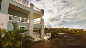 A multi-story building with balconies, surrounded by greenery and a clear sky. - Sea Turtle Studio – Upscale Waterview Retreat, Stunning Sunrises & Full Kitchen! (Culebra)