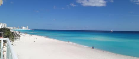 Na praia, espreguiçadeiras, toalhas de praia 