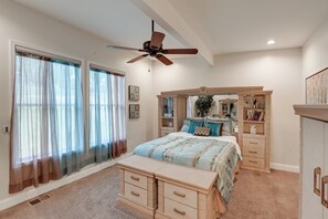 Ein Schlafzimmer mit Bett, Schminktisch, Kommode und Deckenventilator.