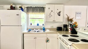 A compact kitchen with white cabinets, a refrigerator, a stove, and a sink. - Escape to Nature - 2 miles from Ichetucknee park  (Fort White)