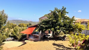 Una casa con patio, mobiliario exterior y vistas del paisaje circundante.