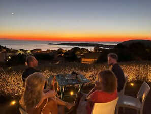 A group of people seated around a table with a view of the sunset over the ocean. - House / Villa - Cargèse (Cargèse)