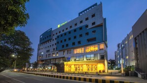 Ein mehrgeschossiges Hotel mit einem gut sichtbaren "Holiday Inn Express"-Schild, das ein modernes architektonisches Design mit großen Fenstern und einer gut beleuchteten Fassade aufweist.