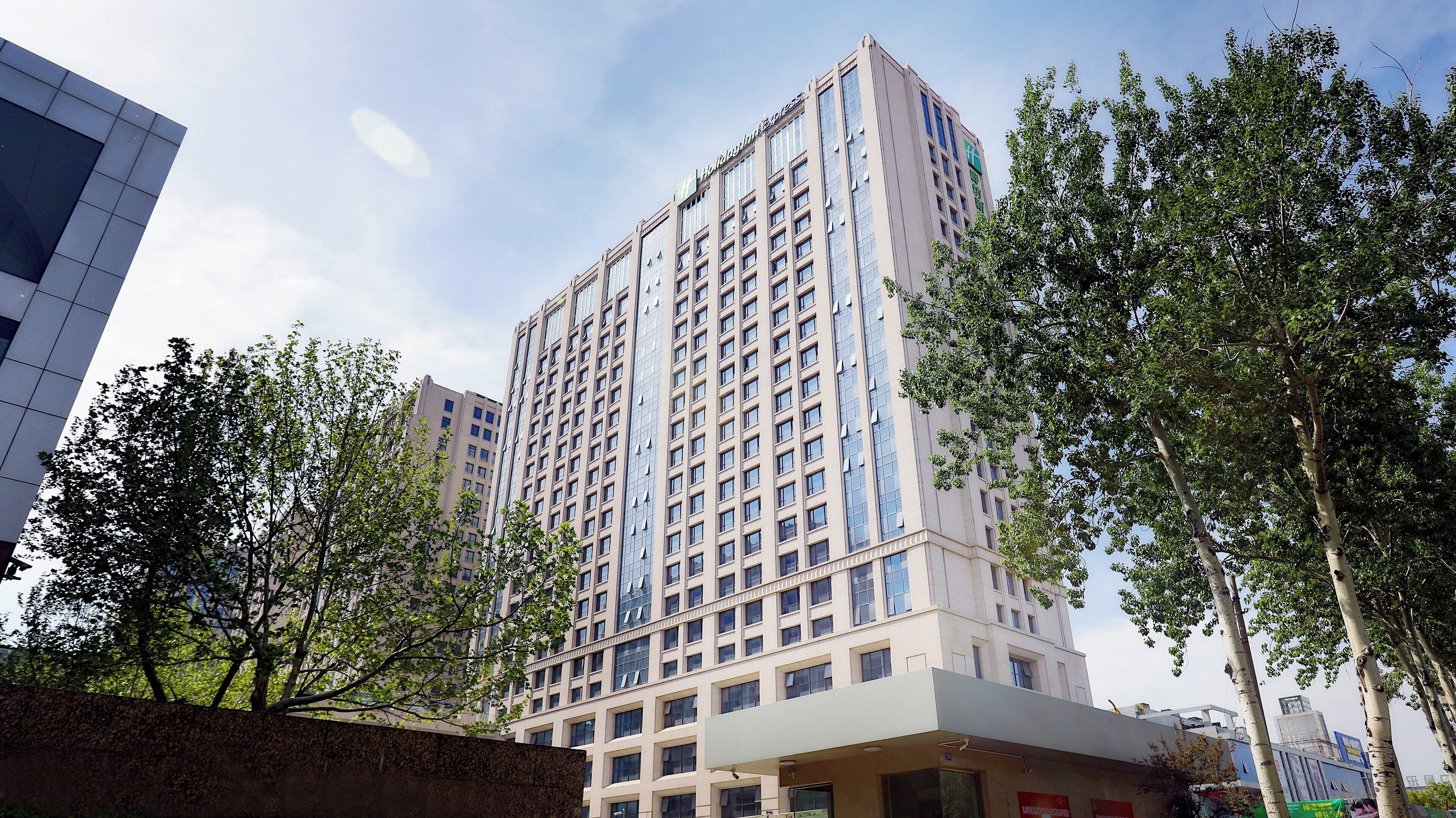 A multi-story hotel with a modern facade, large windows, and a flat roof.
