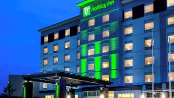 Un hôtel Holiday Inn doté d’une façade moderne, de plusieurs étages et d’une entrée bien éclairée.