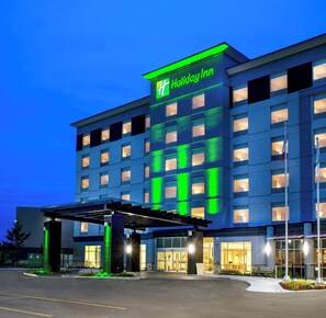 A Holiday Inn hotel with a modern facade, multiple floors, and a well-lit entrance.