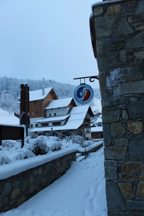 A snow-covered building with a stone wall and a sign indicating a ski resort. - Very nice apartment skis Chamonix Valley (Les Houches)