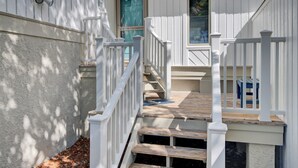 A staircase with white railings leading to a door with a green window. - Award-Winning Resort Amenities | Racquet Club Villa 23 (Isle of Palms)