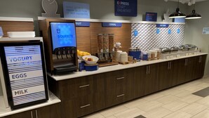 A breakfast bar with yogurt, eggs, and milk dispensers, a fruit bowl, and a sign for express breakfast. - Holiday Inn Express & Suites Junction by IHG (Junction)