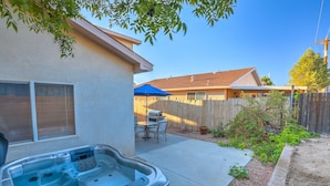 A backyard with a hot tub, a barbecue area, and a wooden fence. - "The Fontana" 4bedrooms,  Hot Tub, Patio Mister,Pets Welcome, 5G Fiber Internet! (Albuquerque)