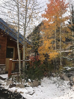 A wooden cabin with a snow-covered porch and a stone wall. - Spacious Family Home Close to 4 Ski Resorts, Summit County CO- Mountain Serenity (Silverthorne)