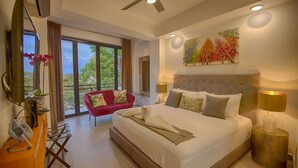 A modern bedroom with a large bed, a red sofa, and a balcony with a view. - Casa Isacamil - Impeccable Views, Contemporary, Rooftop Pool, Proximity to Town (5 de Diciembre)