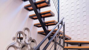 A modern staircase with wooden steps and black metal railings, leading to an upper floor. - Casa Isacamil - Impeccable Views, Contemporary, Rooftop Pool, Proximity to Town (5 de Diciembre)