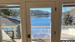 Puerta de madera con vista a un lago y un bosque.