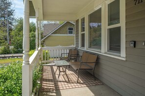 A covered porch with a table and chairs, a small window, and a mailbox.