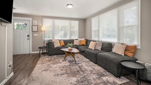 Una sala de estar con un sofá modular, una mesa de centro y un tapete.
