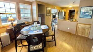 A dining area with a round table, chairs, and a window with blinds.