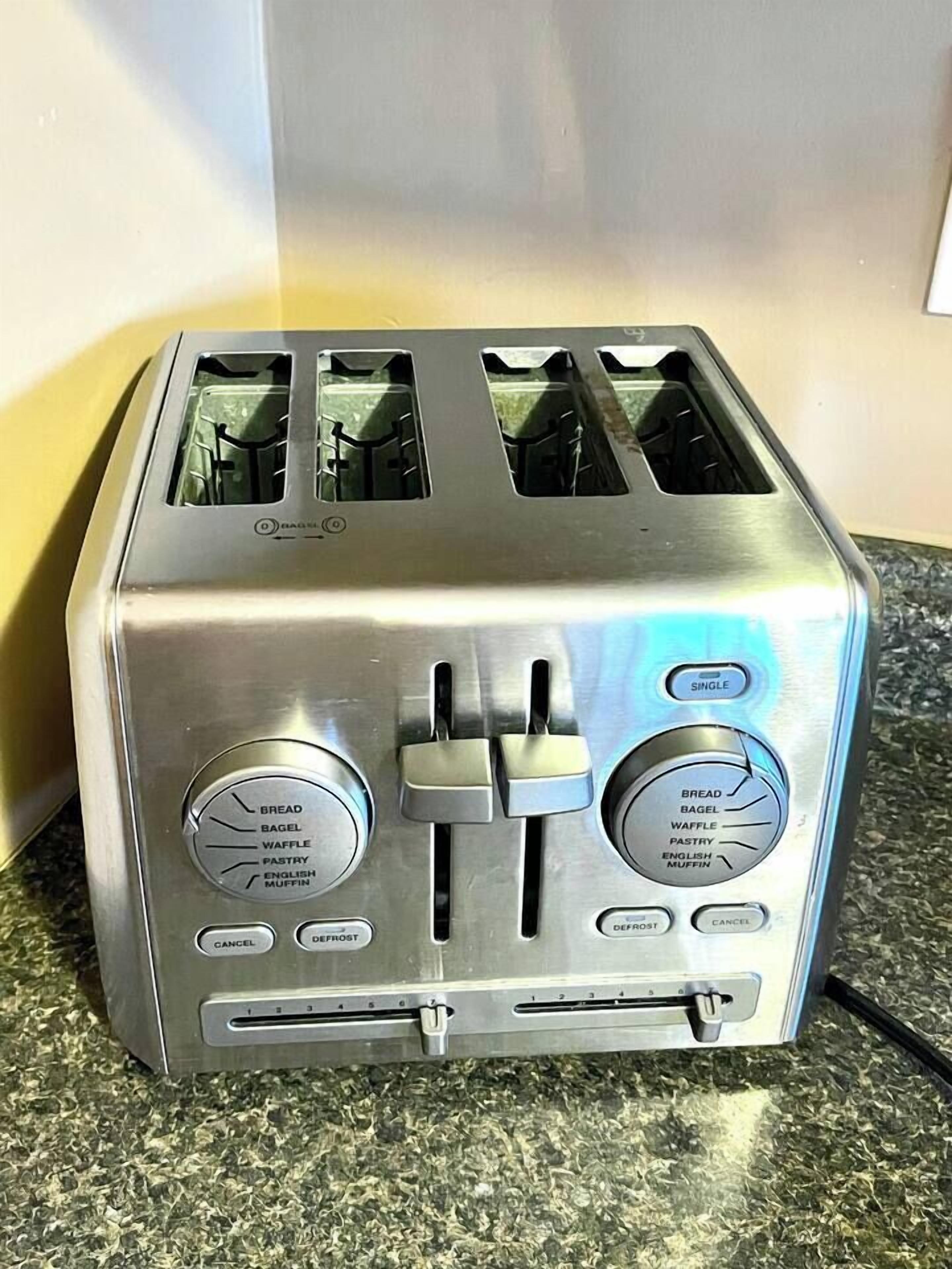 A stainless steel toaster with multiple settings including bread, bagel, waffle, pastry, and English muffin. It has a defrost function and a cancel button.