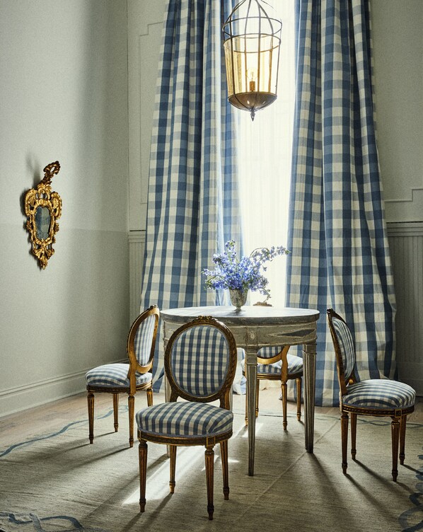 A dining room with a round table, four chairs, a vase with flowers, and a hanging light fixture. - Hotel Peter and Paul, an Ash Hotel (New Orleans)