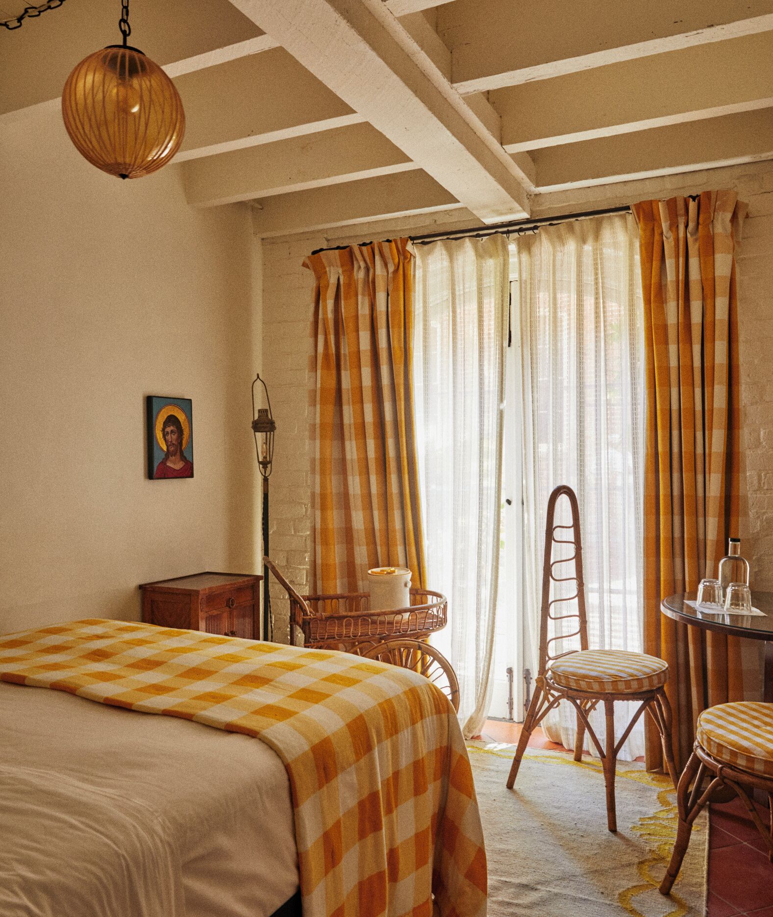 Ein Schlafzimmer mit Bett, Stuhl, Tisch und Lampe.