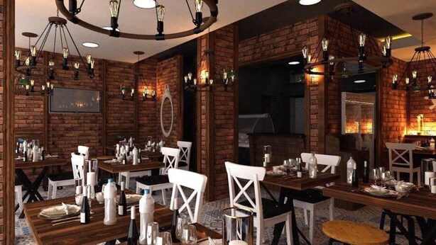 Un restaurant aux murs de briques, aux tables en bois et aux chaises blanches.
