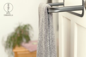 A towel hanging on a metal towel rack attached to a white door. - Hotel Cunnamulla (Cunnamulla)