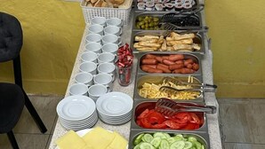 A buffet table with various food items including bread, sausages, cheese, tomatoes, cucumbers, and meat. - Taksim Soushian Hotel (Istanbul)