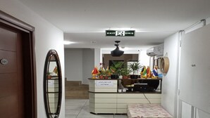 A hallway with a reception desk, a bench, and a door marked with the number 001. - Taksim Soushian Hotel (Istanbul)