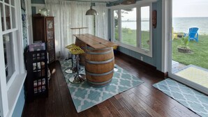 Una habitación con una mesa de caoba, una estantería y vista al mar.