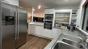 Una cocina moderna con electrodomésticos de acero inoxidable, armarios blancos y encimera de granito.