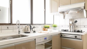 Une cuisine moderne dotée d’un évier en acier inoxydable, d’une cuisinière encastrée et d’un lave-vaisselle.