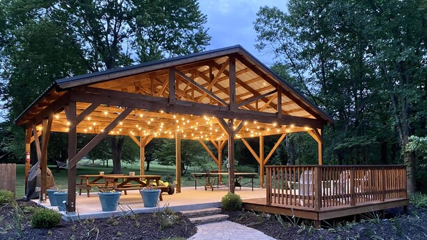 A wooden gazebo with a deck, string lights, and picnic tables. -  Both cottages rent as one unit,  Enjoy Privacy & Comfort, Very Family friendly (Branson)