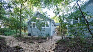 A house with a gravel driveway leading to a wooden deck. -  Both cottages rent as one unit,  Enjoy Privacy & Comfort, Very Family friendly (Branson)