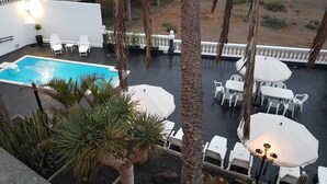 A rooftop pool area with lounge chairs, umbrellas, and a view of the surrounding landscape. - Historical house facing the sea in Finca de Plataneras. (San Andrés)