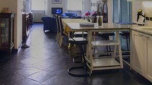 Une cuisine spacieuse avec un coin repas, comprenant un îlot central, des luminaires suspendus et une vue sur la salle à manger.