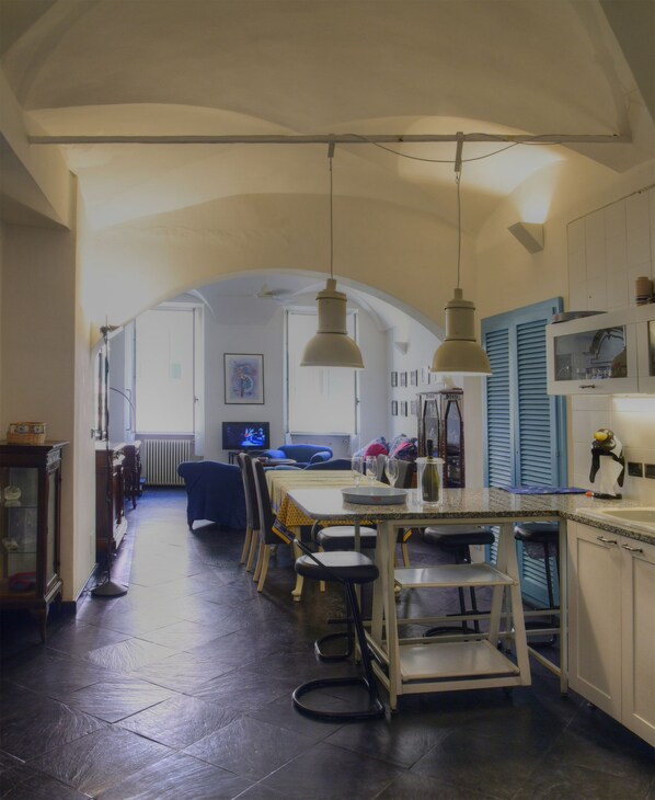 A spacious kitchen with a dining area, featuring a central island, pendant lights, and a view into the dining room.
