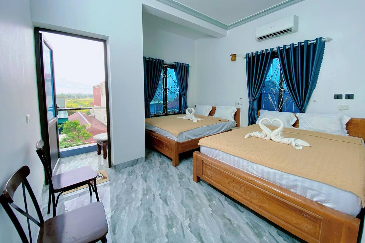 Habitación de hotel con dos camas, una silla y vistas al exterior.
