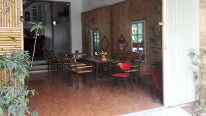 An open-plan dining area with wooden flooring and a high ceiling. - Tamcoc White Swan Hostel (Nam Hoa Lu)