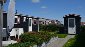 Une rangée de maisons mobiles, avec un chemin menant à un petit abri de jardin.