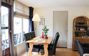 Cozy room with a dining table, comfortable chairs, and a bookshelf.