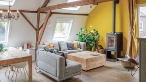A cozy living room with a sofa, coffee table, and a fireplace. - 3 bedroom pet friendly home in Leende (Leende)