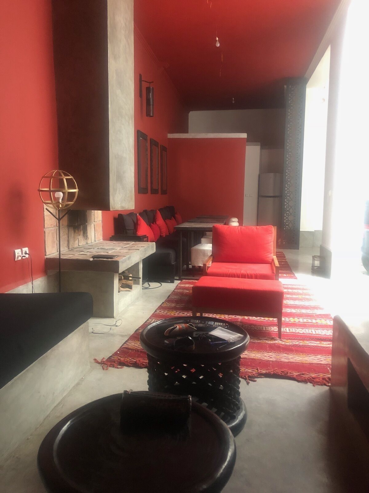 Un salon moderne avec des murs rouges, un canapé, une table basse et un lampadaire.