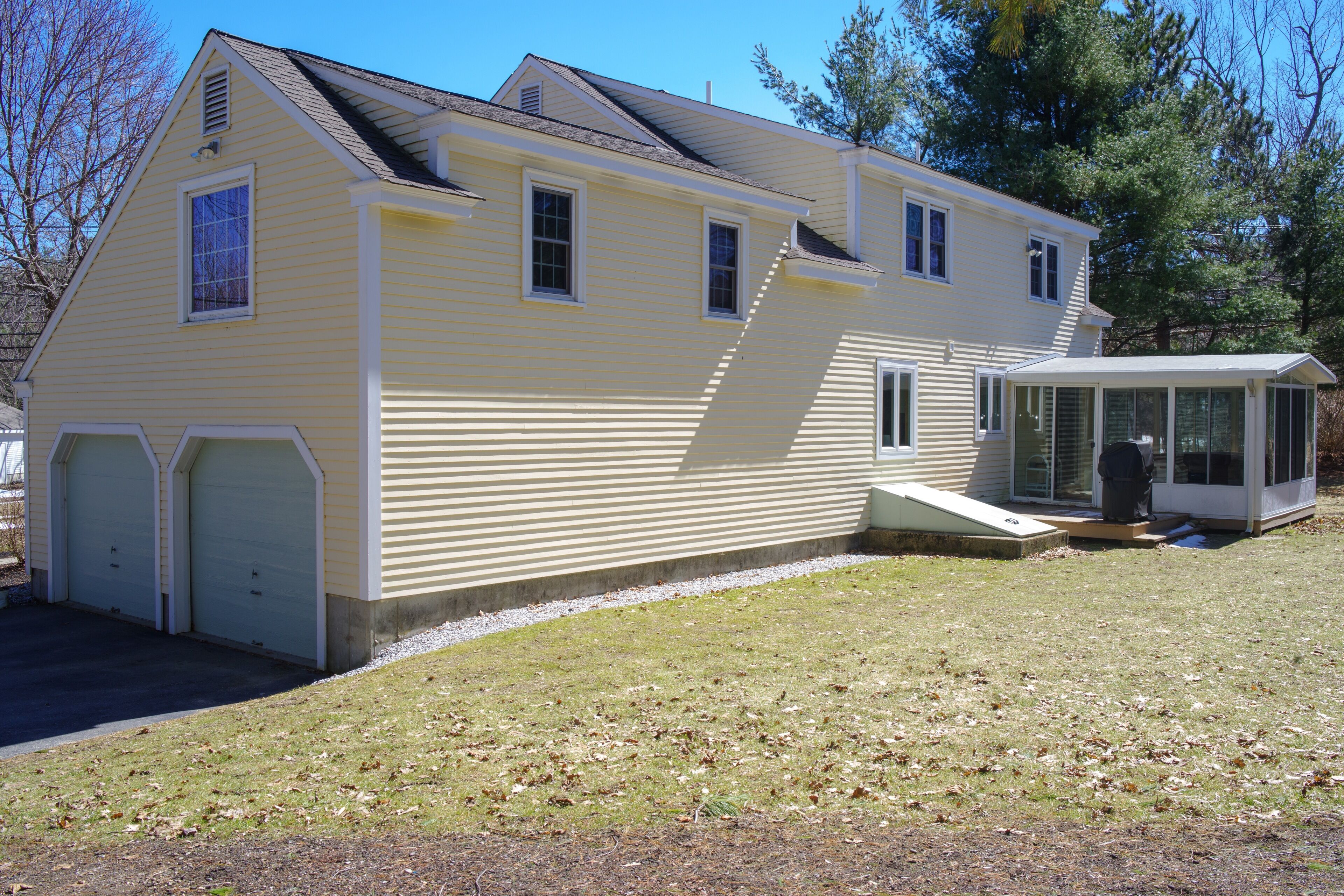 A two-story house with a garage, a covered porch, and a small shed.