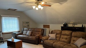 A living room with two brown leather sofas, a ceiling fan, a window with blinds, and a framed picture on the wall. - Wachusett Mountain Getaway, Lake Adjacent Home! Near 1761 Old Mill and Trails! (Westminster)