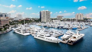 A marina with multiple yachts docked, surrounded by modern buildings and clear skies. - Luxury 2 bedroom condo on Palm Beach Island! (Palm Beach)