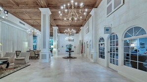 A spacious lobby with high ceilings, chandeliers, and a central round table. - Luxury 2 bedroom condo on Palm Beach Island! (Palm Beach)